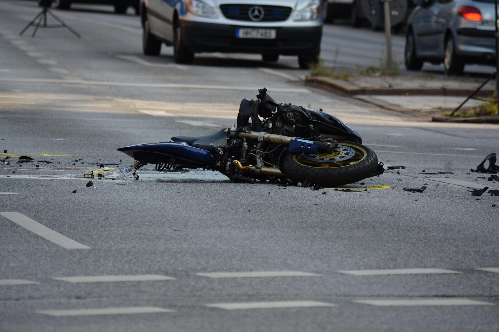 Damaged motorcycle lying on a road after a traffic accident.